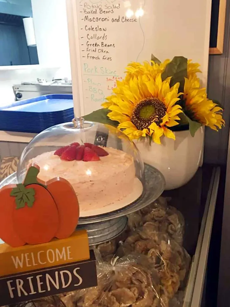 Strawberry cake on counter with pork skins and display items