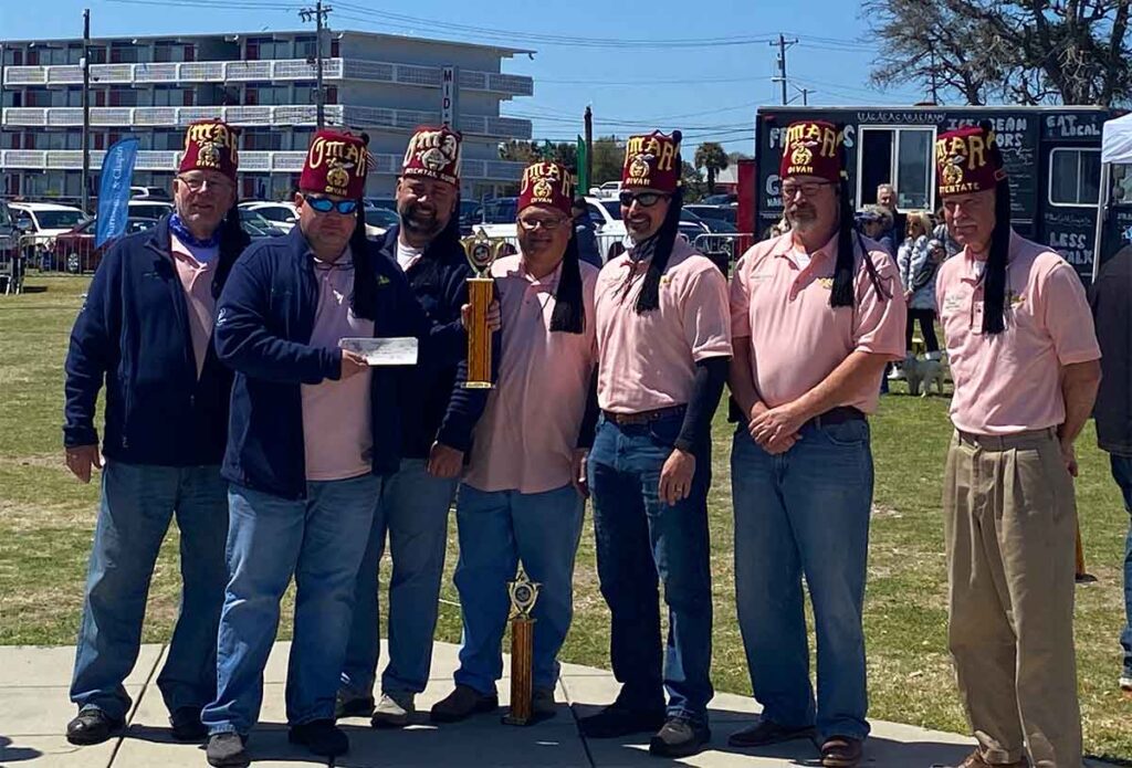 Omar Shriners holding a check and trophy at Smoke on the Beach