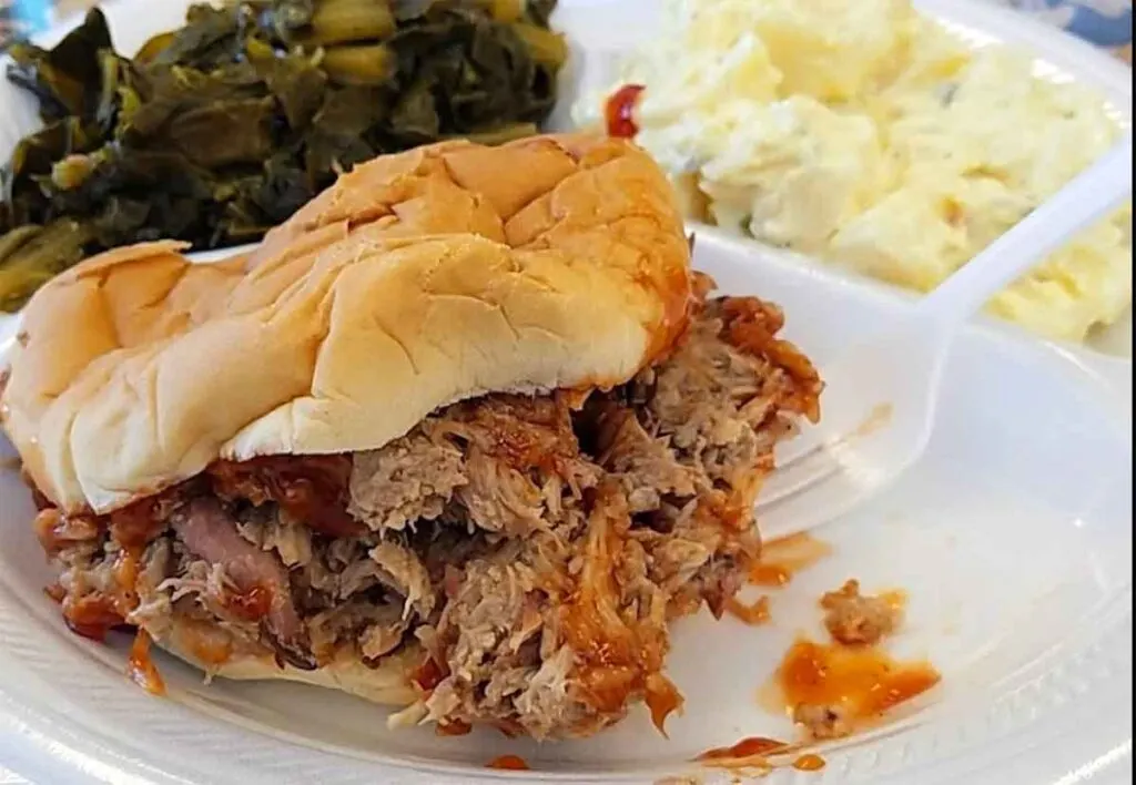 Barbecue sandwich and sides on styrofoam plate