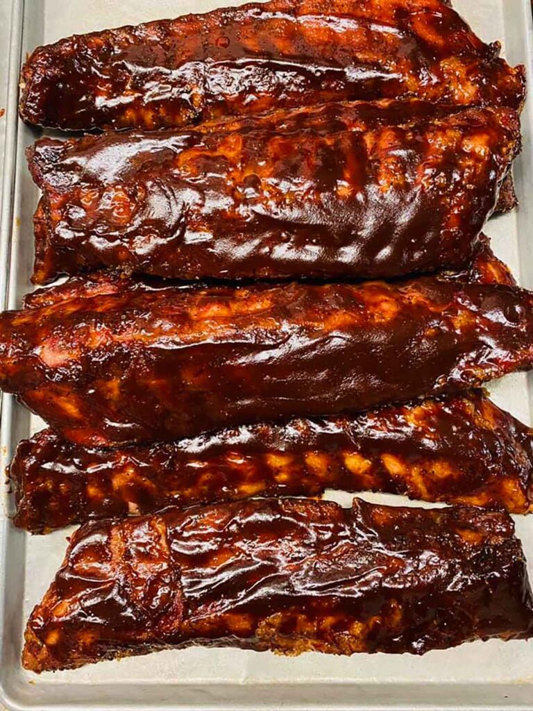 Tray of ribs covered in BBQ sauce