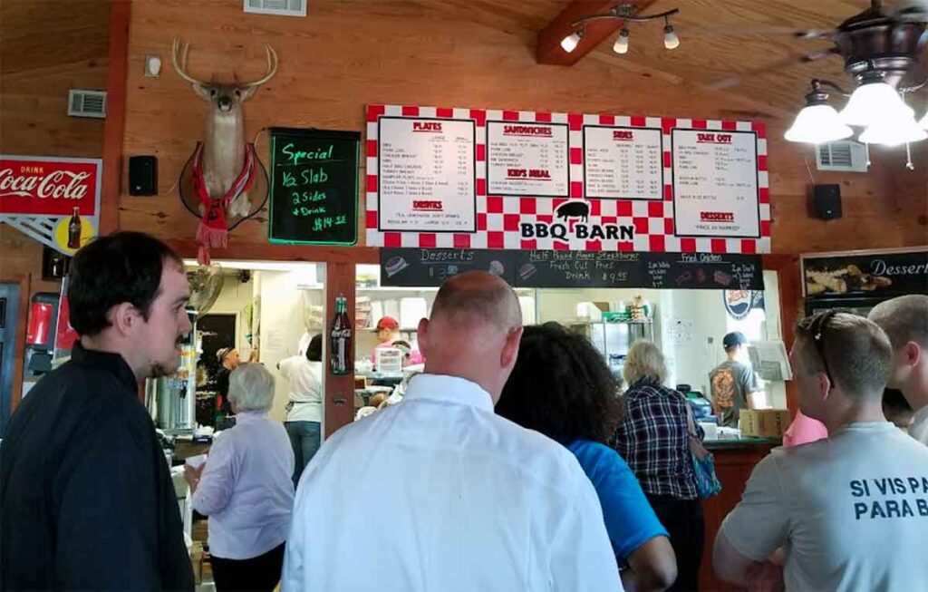 Line of people waiting to order at counter inside of BBQ Barn