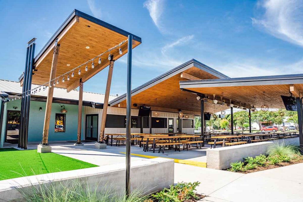 Exterior shot of Lewis BBQ showing covered outdoor seating area with lots of nice "picnic tables."
