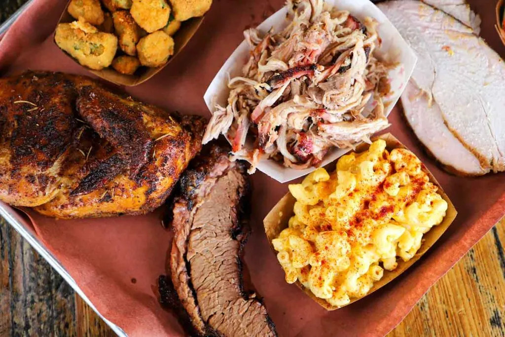 BBQ tray with chicken half, brisket, pulled pork and sides.