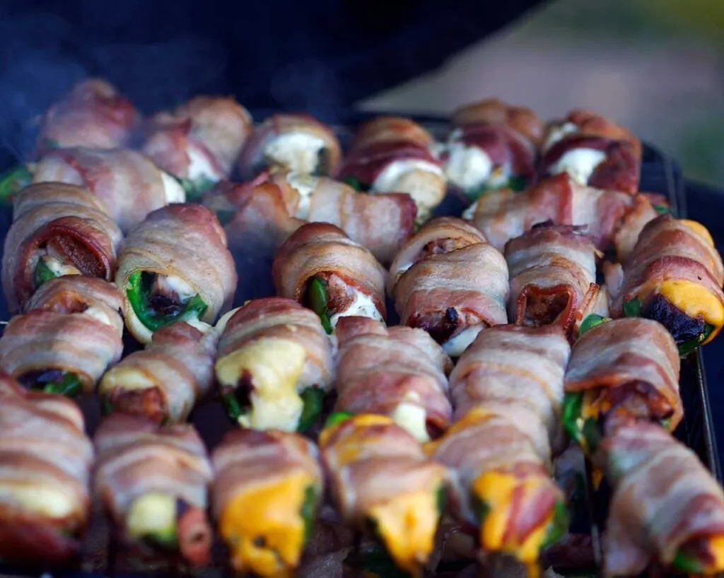 Closeup of several rows of Atomic Buffalo Turds smoking on a grill.