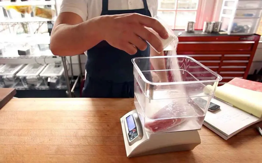 Weighing meat and water on kitchen scale and adding salt to create correct solution based on weight for equilibrium brining.