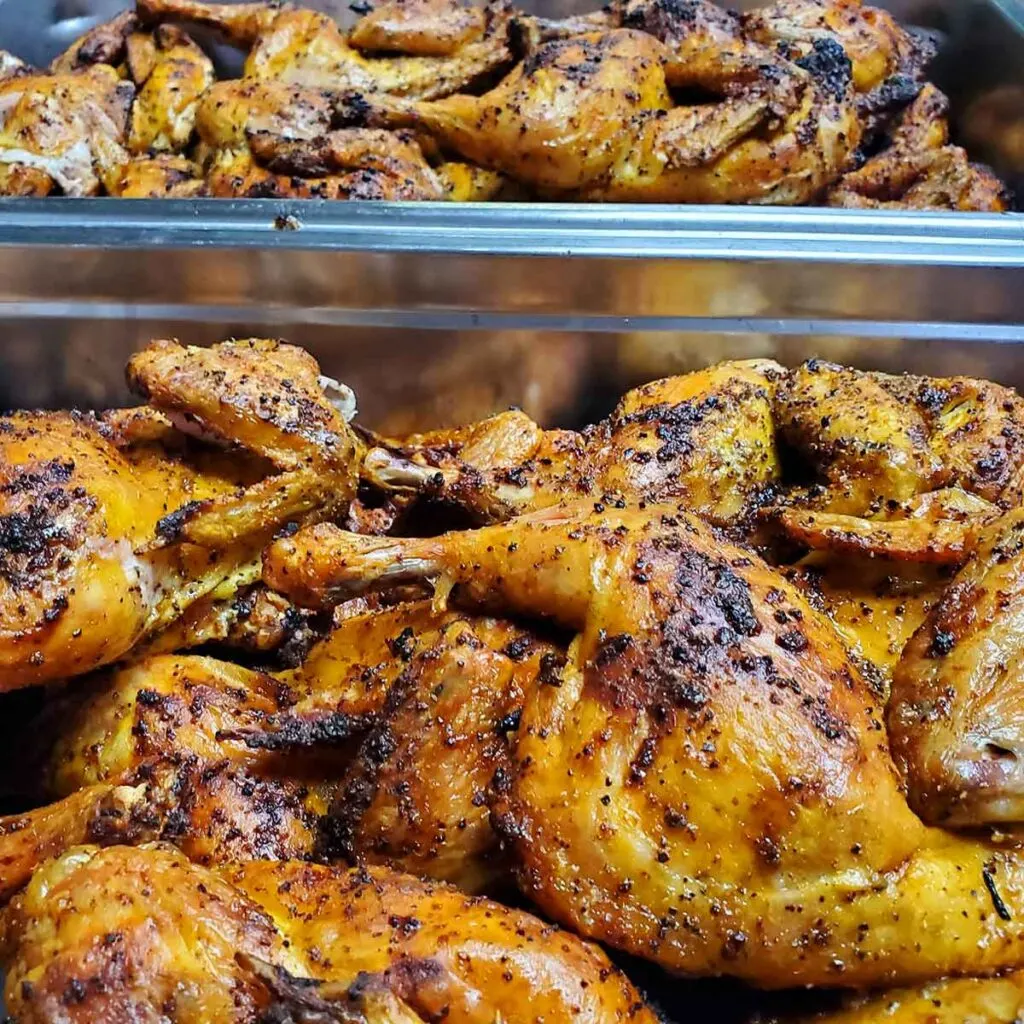 Trays of yellow smoked chicken with nice bark.