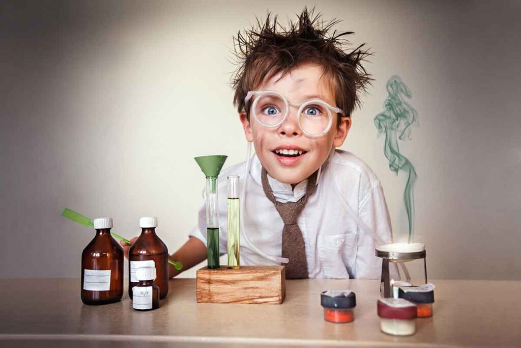 Disheveled kid in glasses and dressed like an adult conducting a science experiment. Explosion implied but not seen.