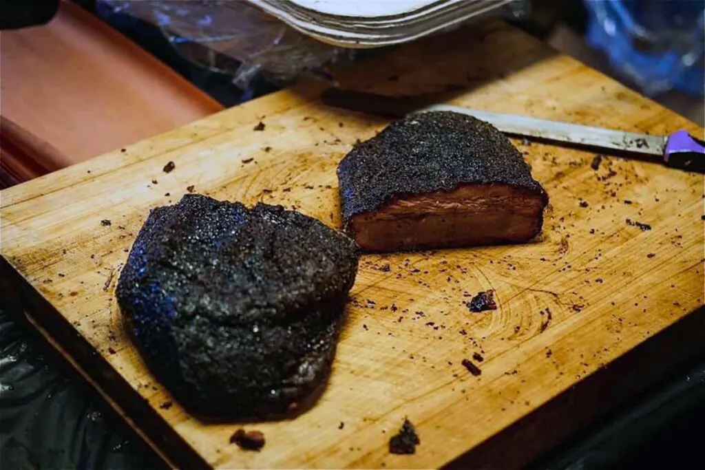 Brisket on cutting board, sliced in half.