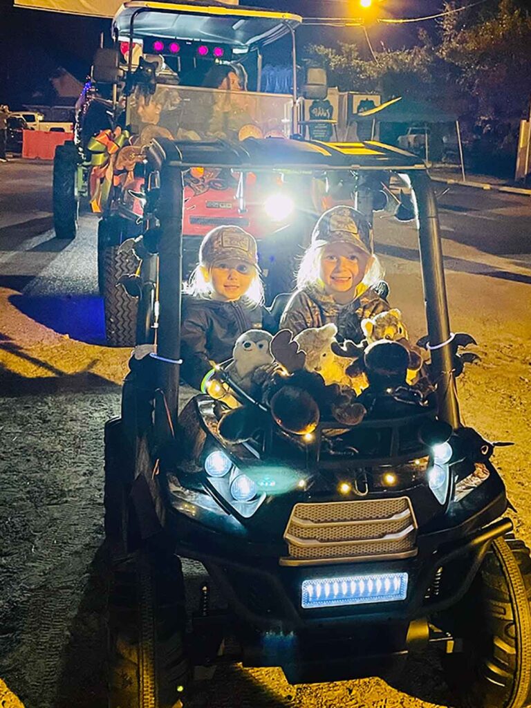 Cute kids driving in a parade at night for the Hook and Cook Festival in Jackson, SC.