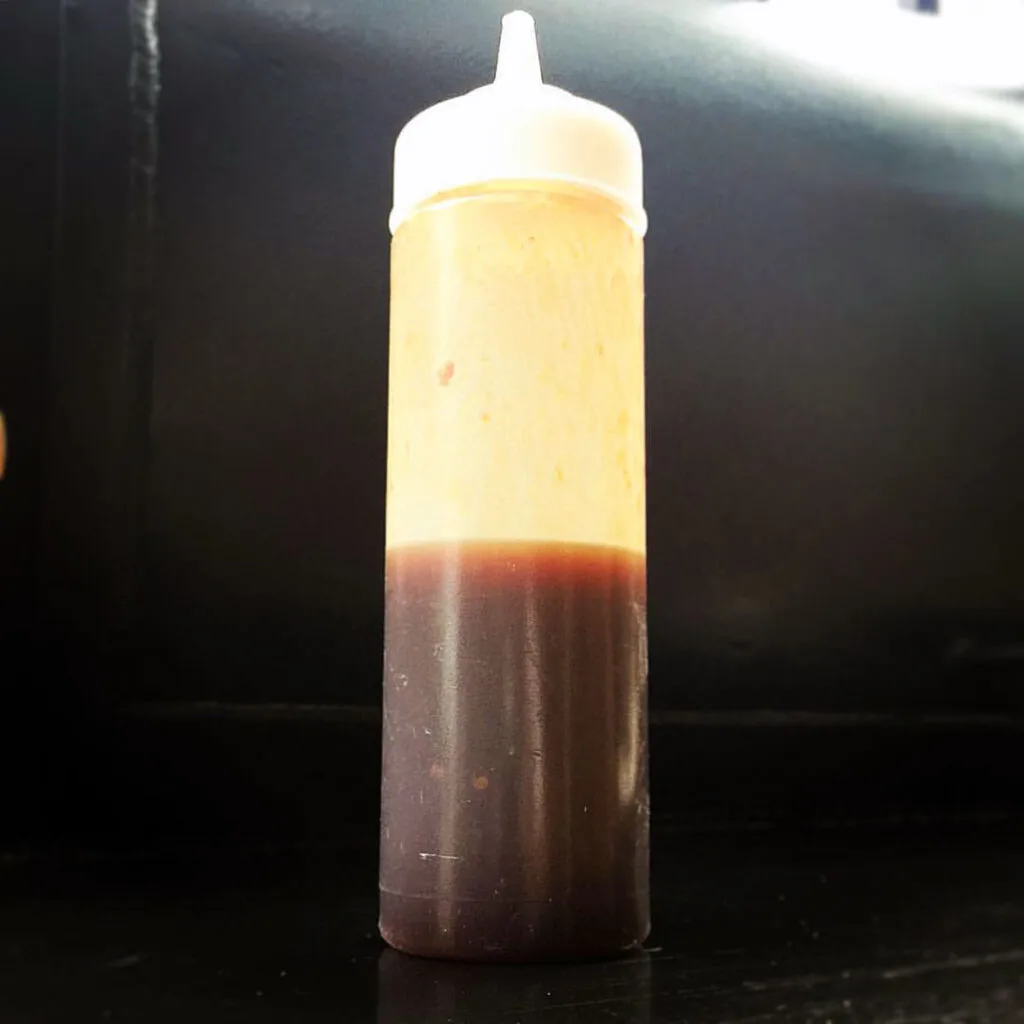 Bottle of sauce on a smoker.