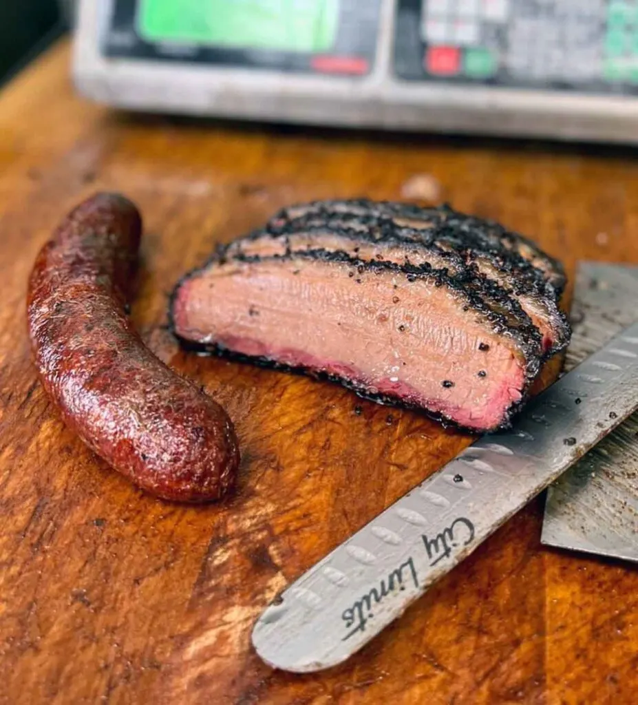 Sausage and sliced brisket on cutting board.