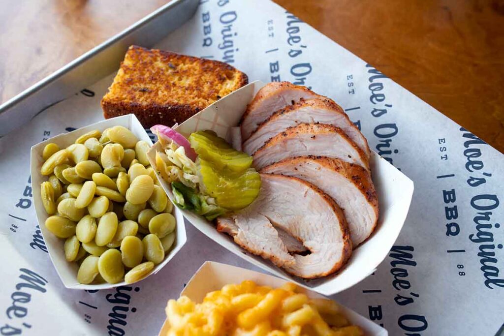 Tray with smoked turkey slices and sides.