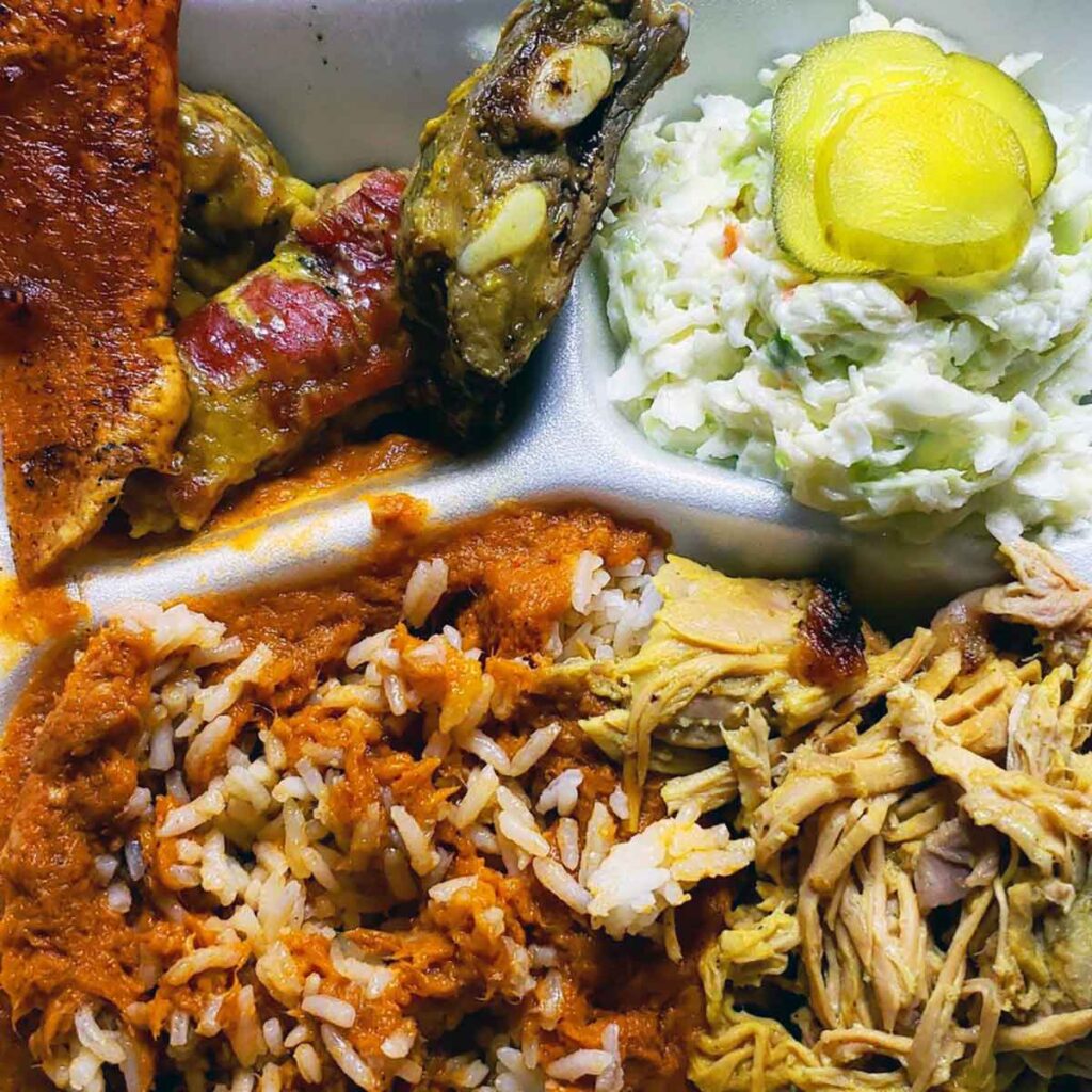 Closeup of hash and rice, chopped BBQ and sides.