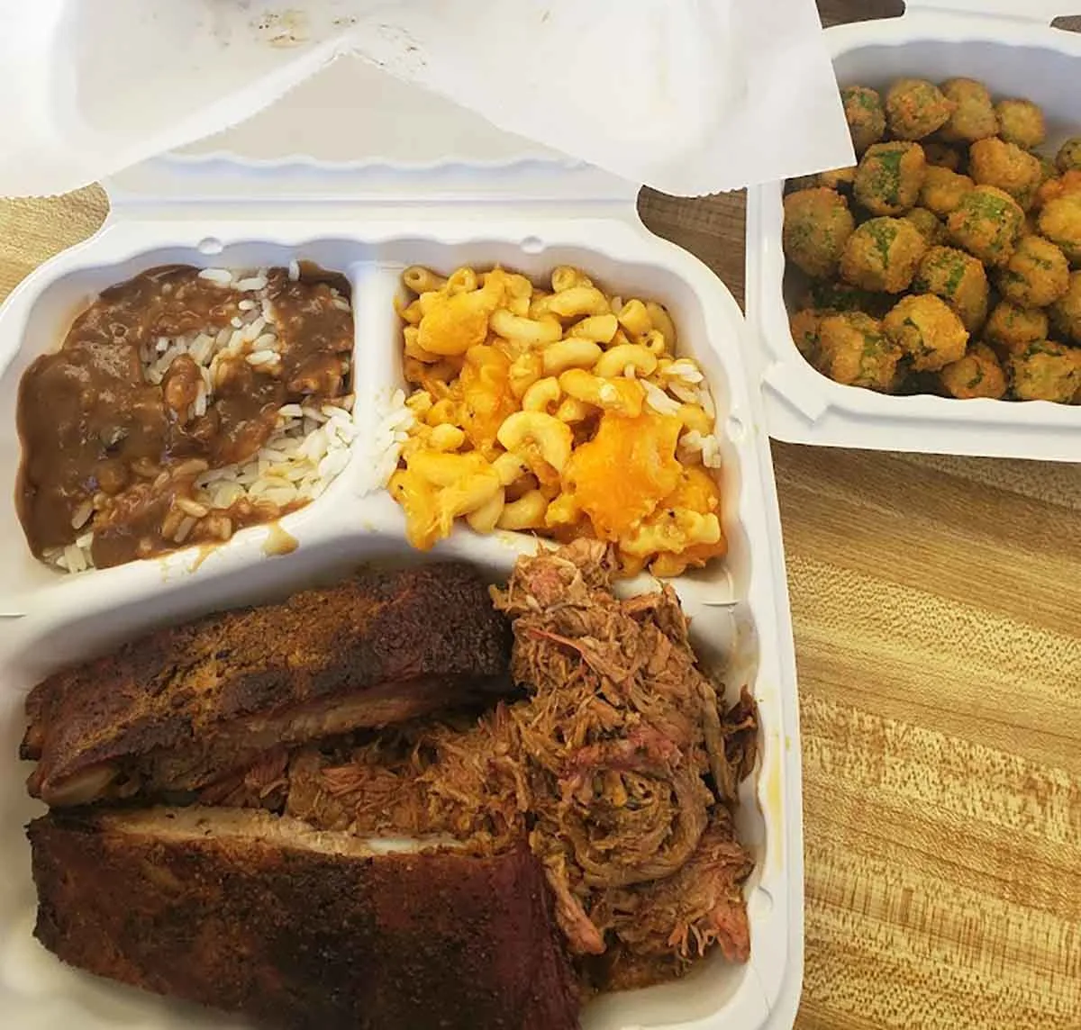Styrofoam tray with ribs, bbq, and sides.
