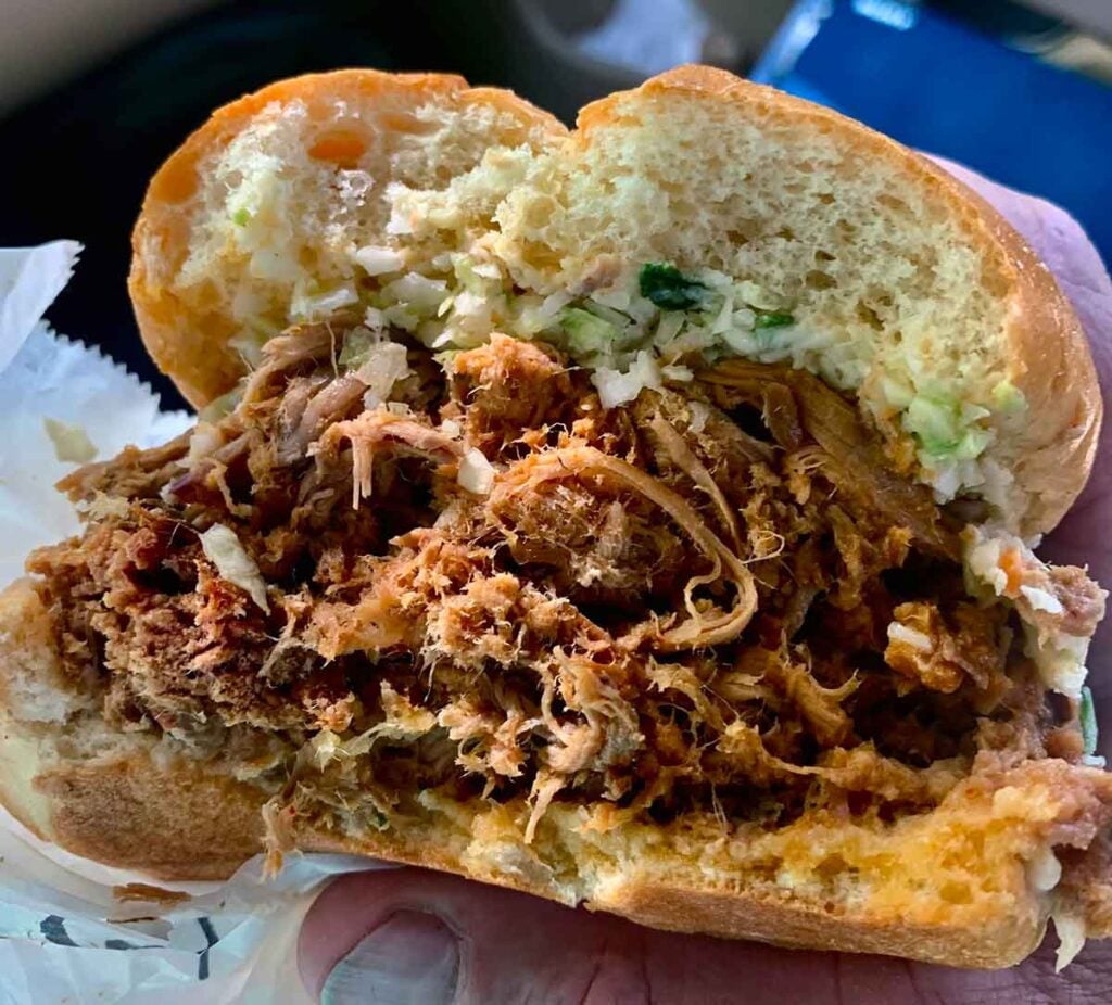 Closeup of barbecue sandwich, half eaten.