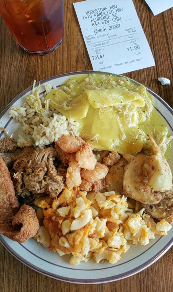 Overhead view of plate with seafood, BBQ and sides.