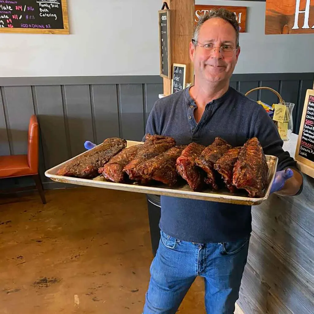 Porkette owner Chris Durham holding a tray of ribs.