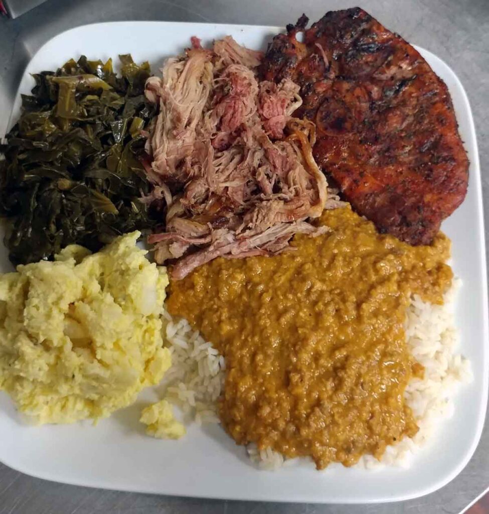 Pulled pork plate with pork chop, hash, and sides.