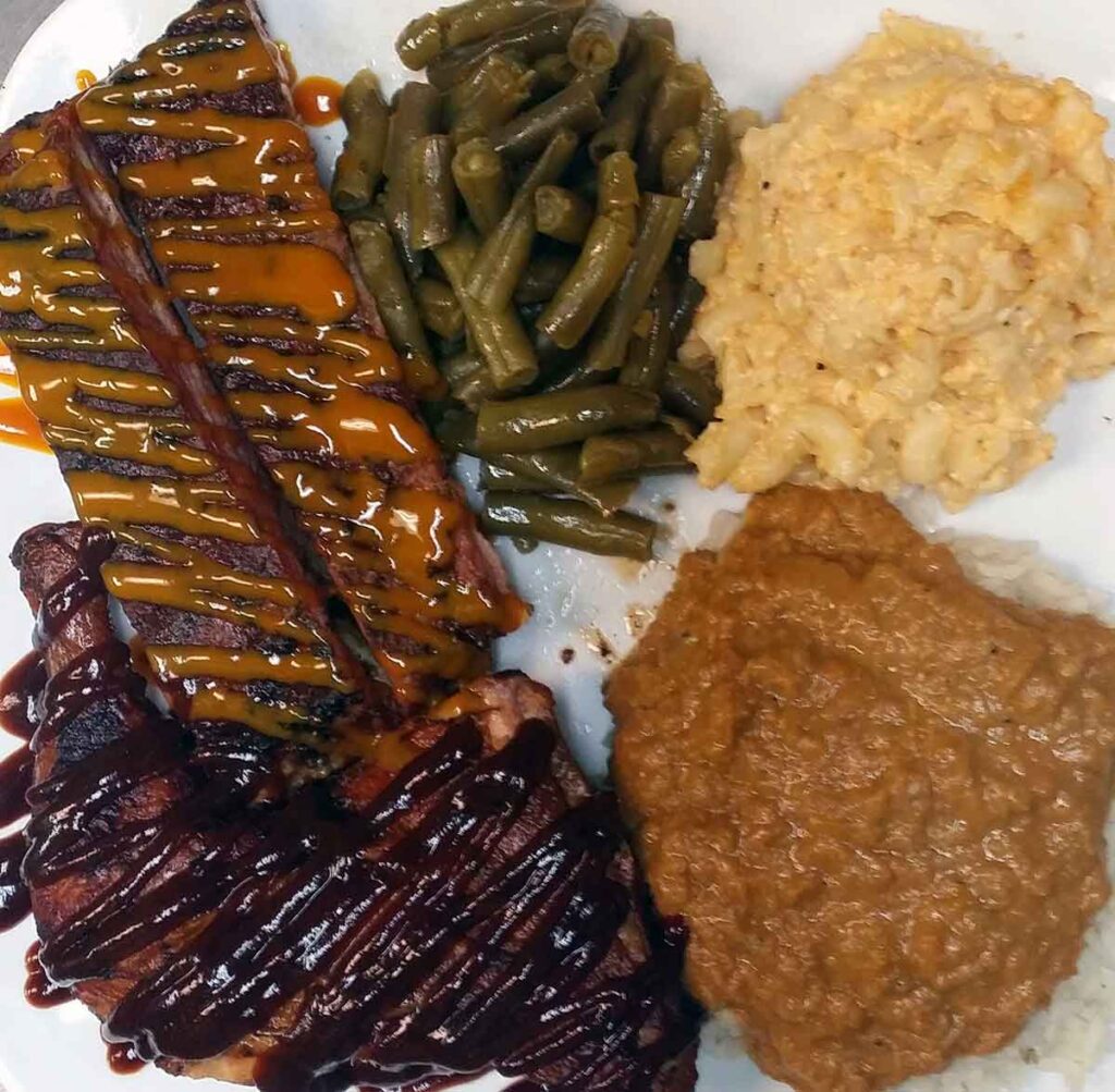 Sauced ribs and chicken with sides.