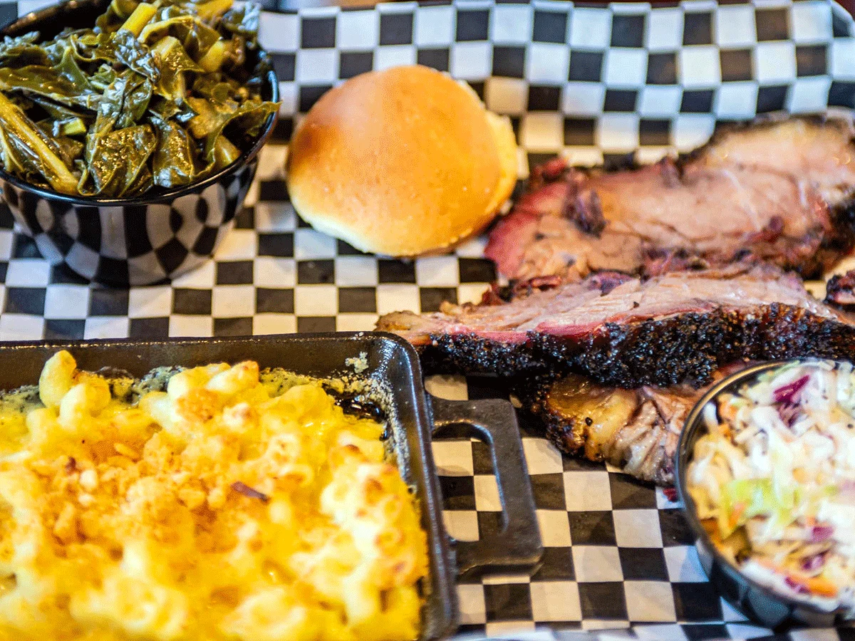 Sliced brisket with sides of collards and Mac and cheese.