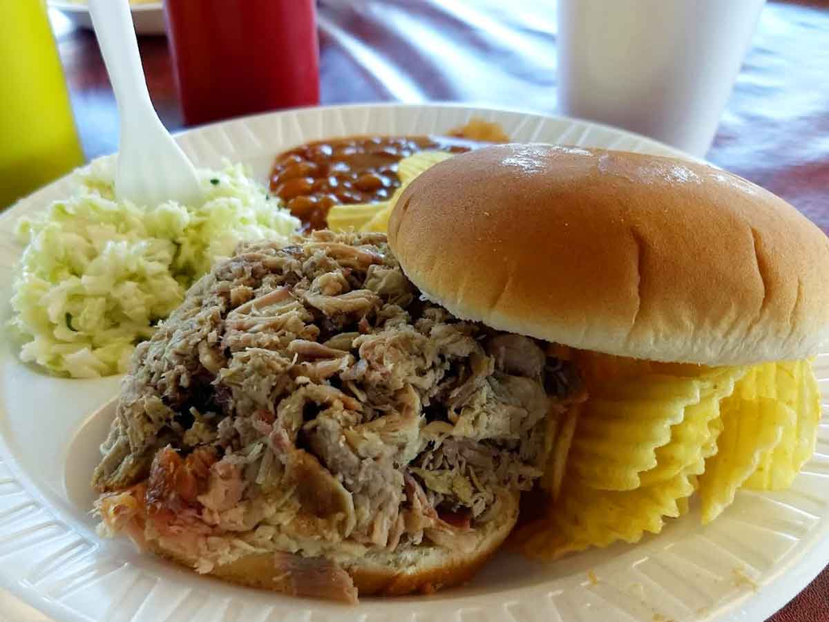 BBQ sandwich with baked beans, slaw, and chips.