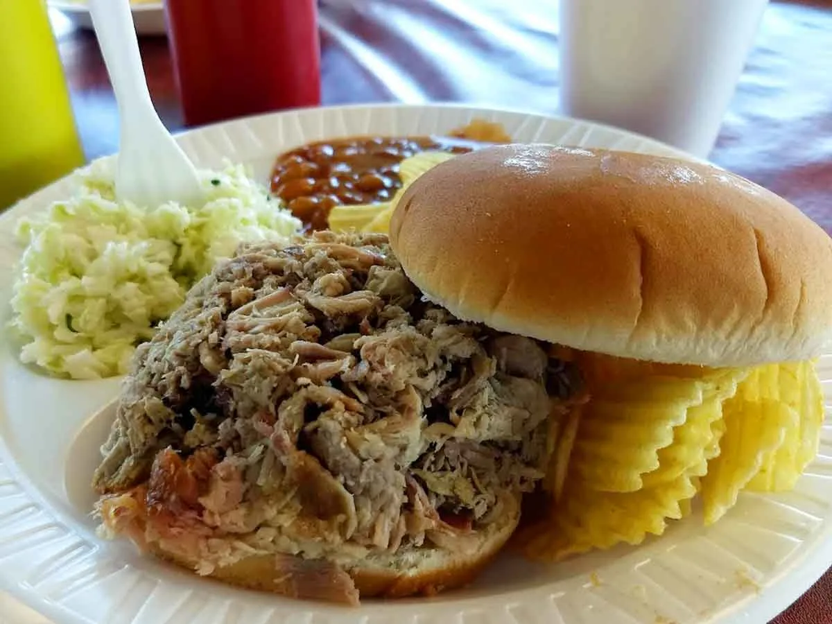 BBQ sandwich with baked beans, slaw, and chips.