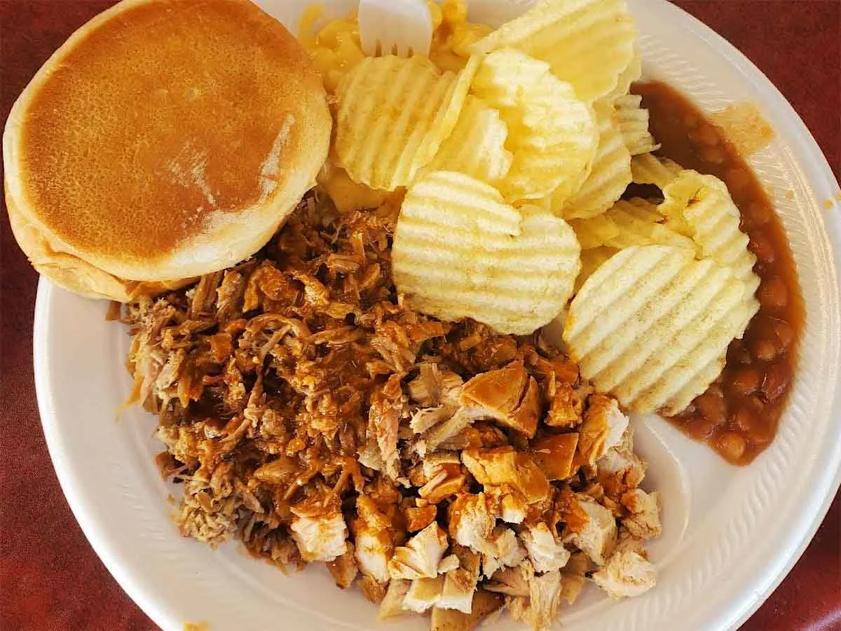 Chopped pork with sauce, baked beans, and chips.