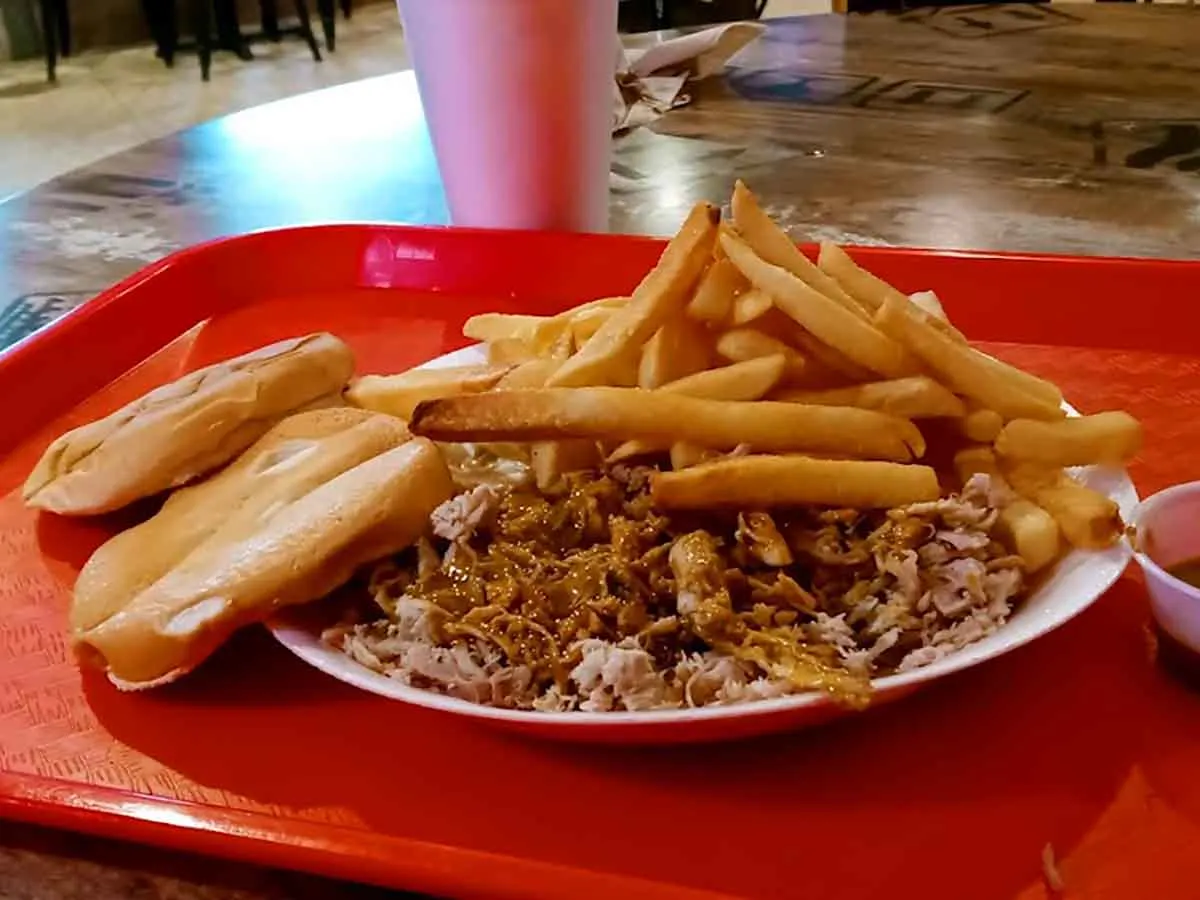 Pulled pork with bun and fries.