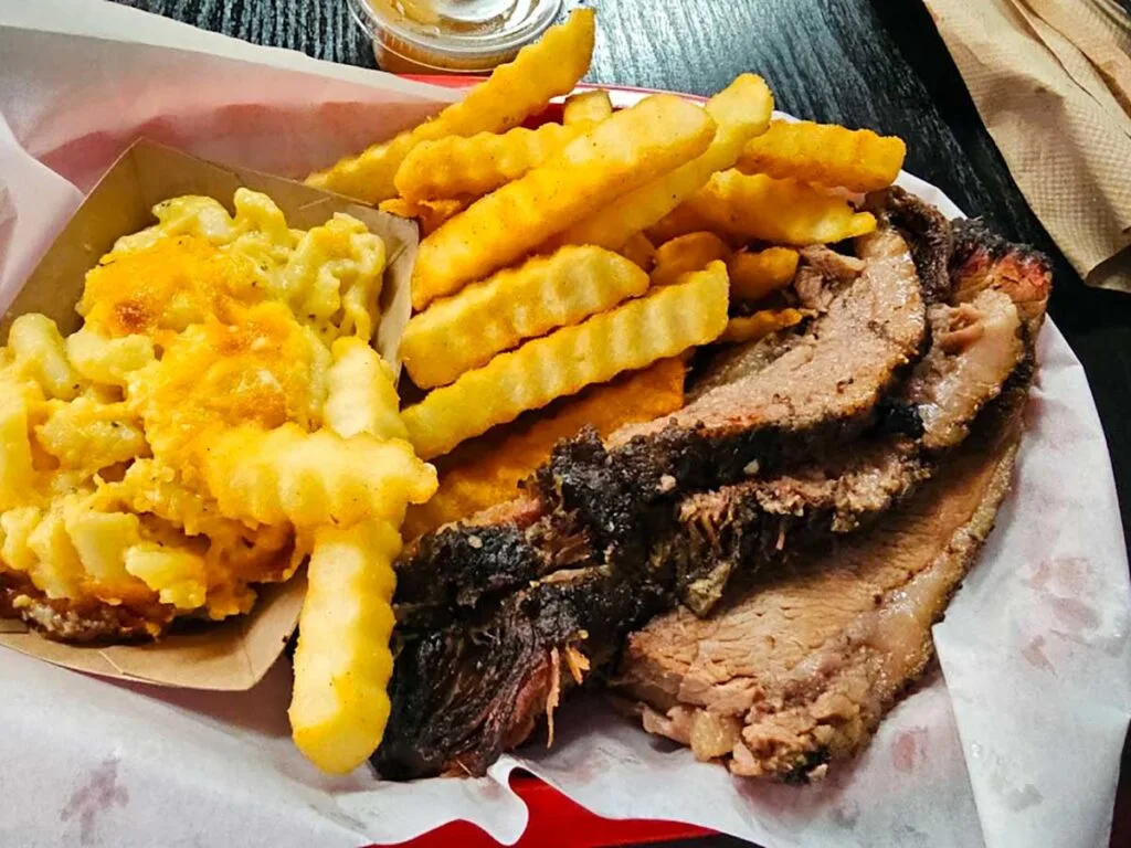 Sliced brisket with fries and Mac and cheese.