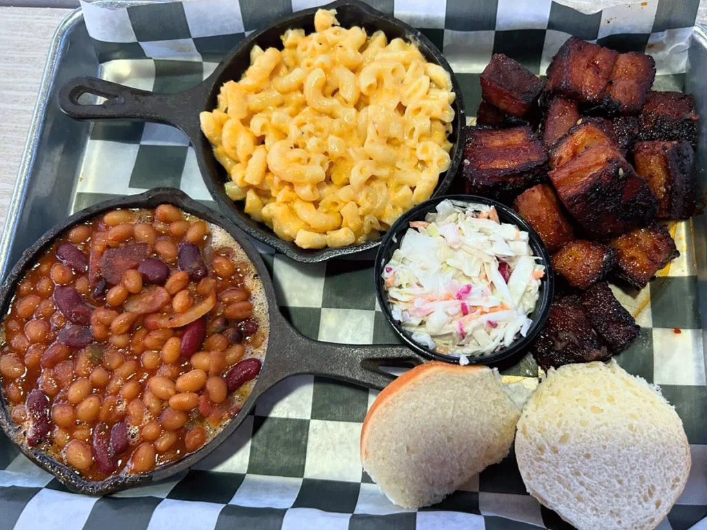 Burnt ends with sides of baked beans, slaw, and Mac and cheese.
