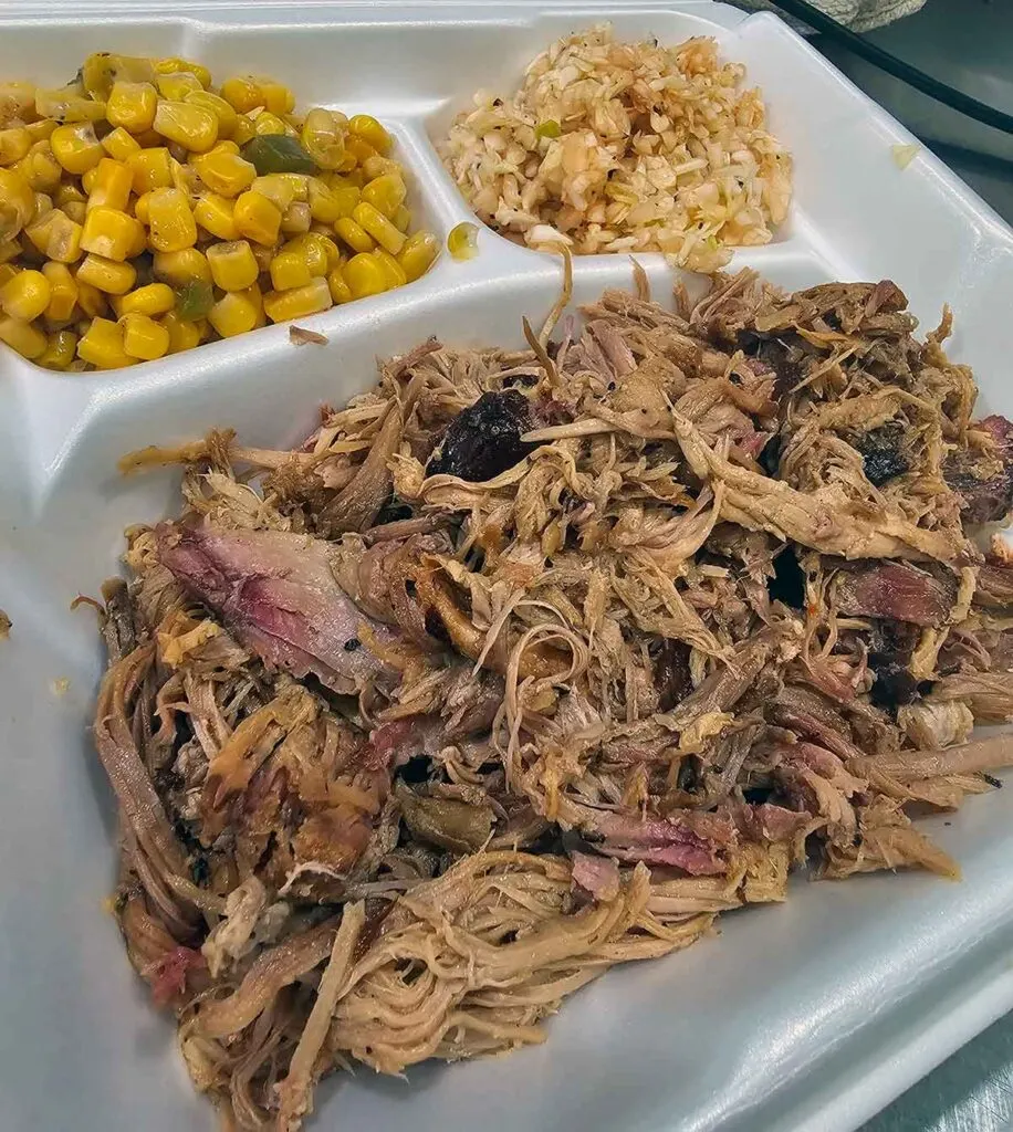 Take-out tray of pulled pork, corn, and BBQ slaw.