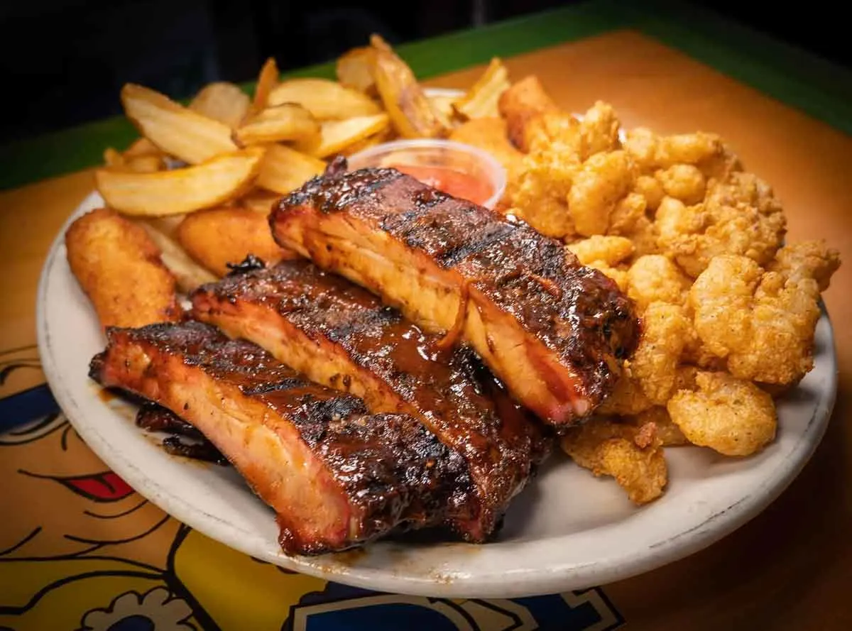 Ribs with fried shrimp and fries.