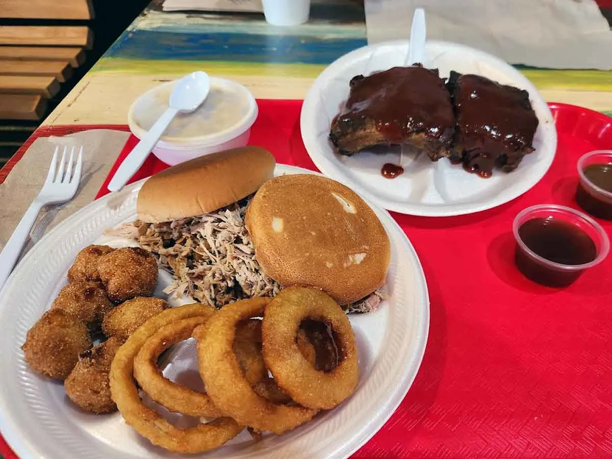 BBQ sandwich with ribs, onion rings and hush puppies.