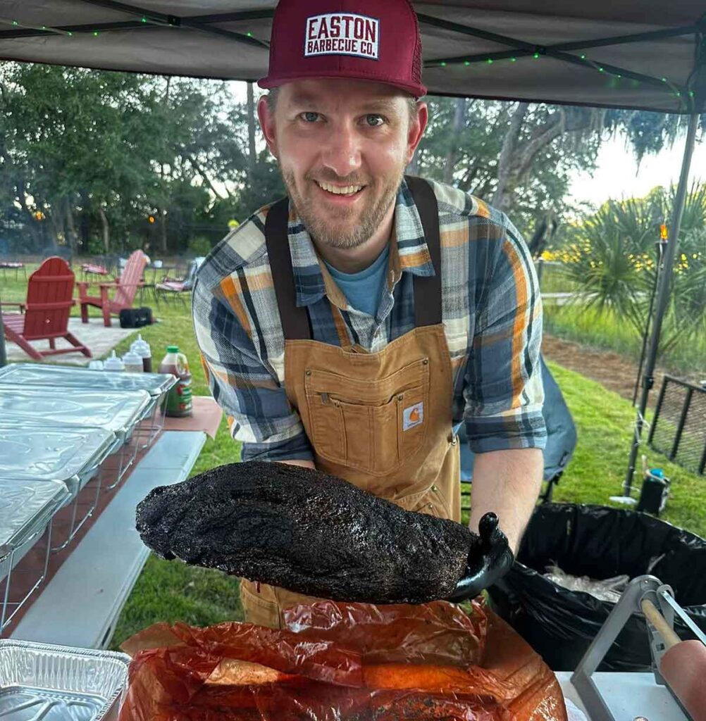 Joel Easton holding a finished brisket.