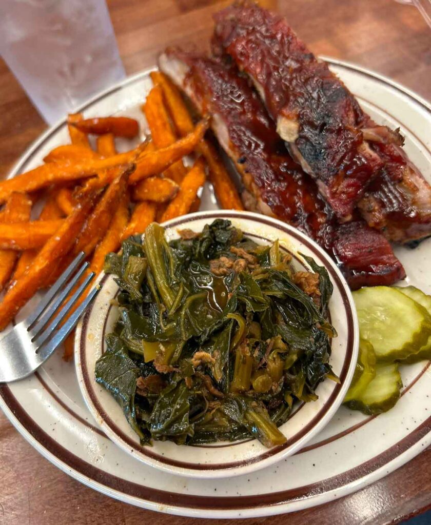Rib plate with sweet potato fries, collards, and pickles.
