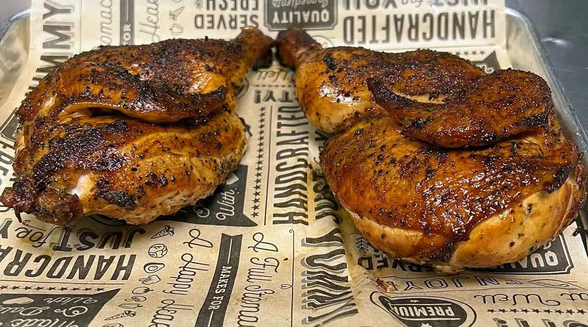 Two golden chicken halves on a tray.