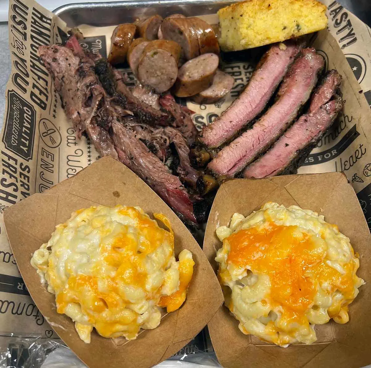 Platter with ribs, pork, sausage, and sides.