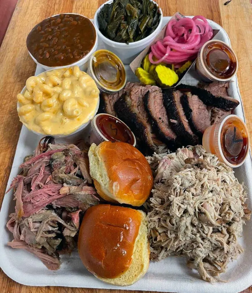 Tray with meats, sides, rolls, and sauces by Moohogz.