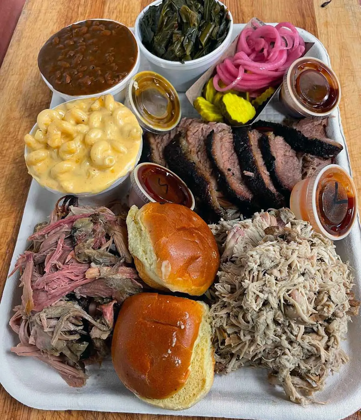 Tray with meats, sides, rolls, and sauces by Moohogz.