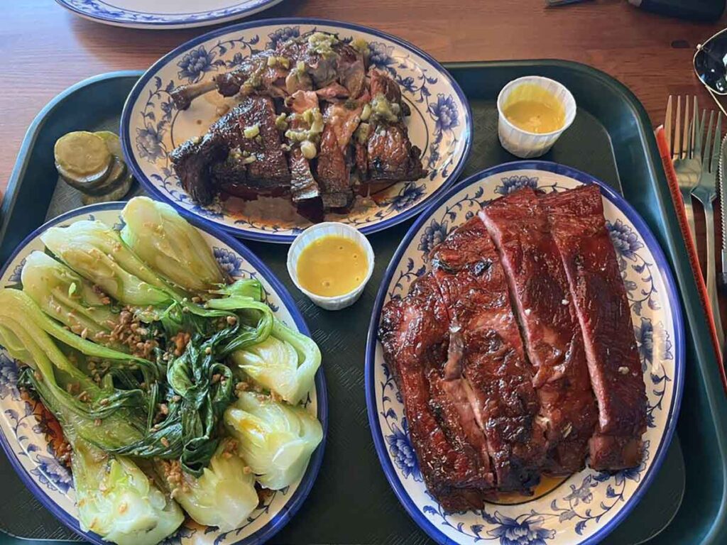Three plates each with bok choy, duck, and ribs.