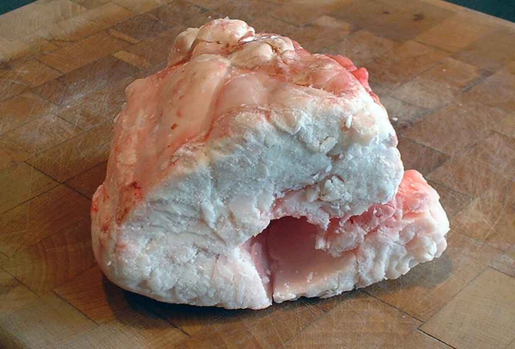 Chunk of beef suet on cutting board.