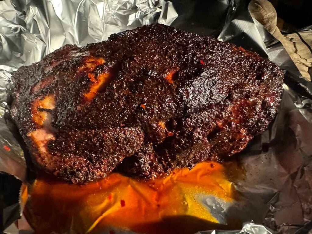 Pork shoulder in foil with liquid.