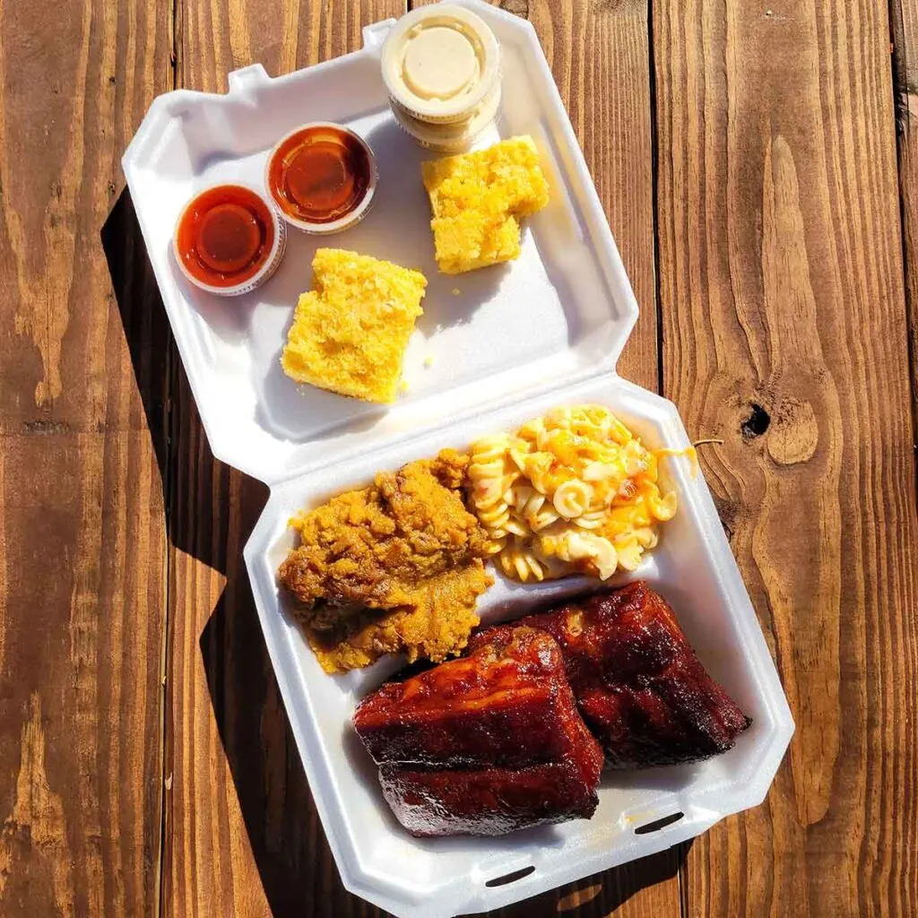 Takeout tray of ribs and sides from Roller Mills Smokehouse.