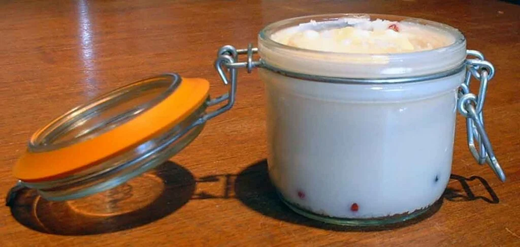 Mason jar with clamping lid and rubber gasket full of white tallow.