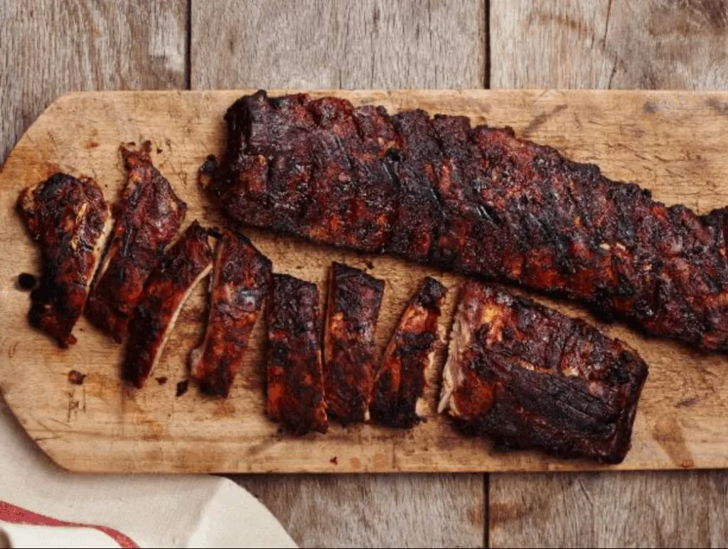 Maple-smoked ribs sliced on cutting board.