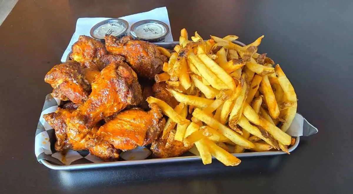 Wings and fries on serving tray.