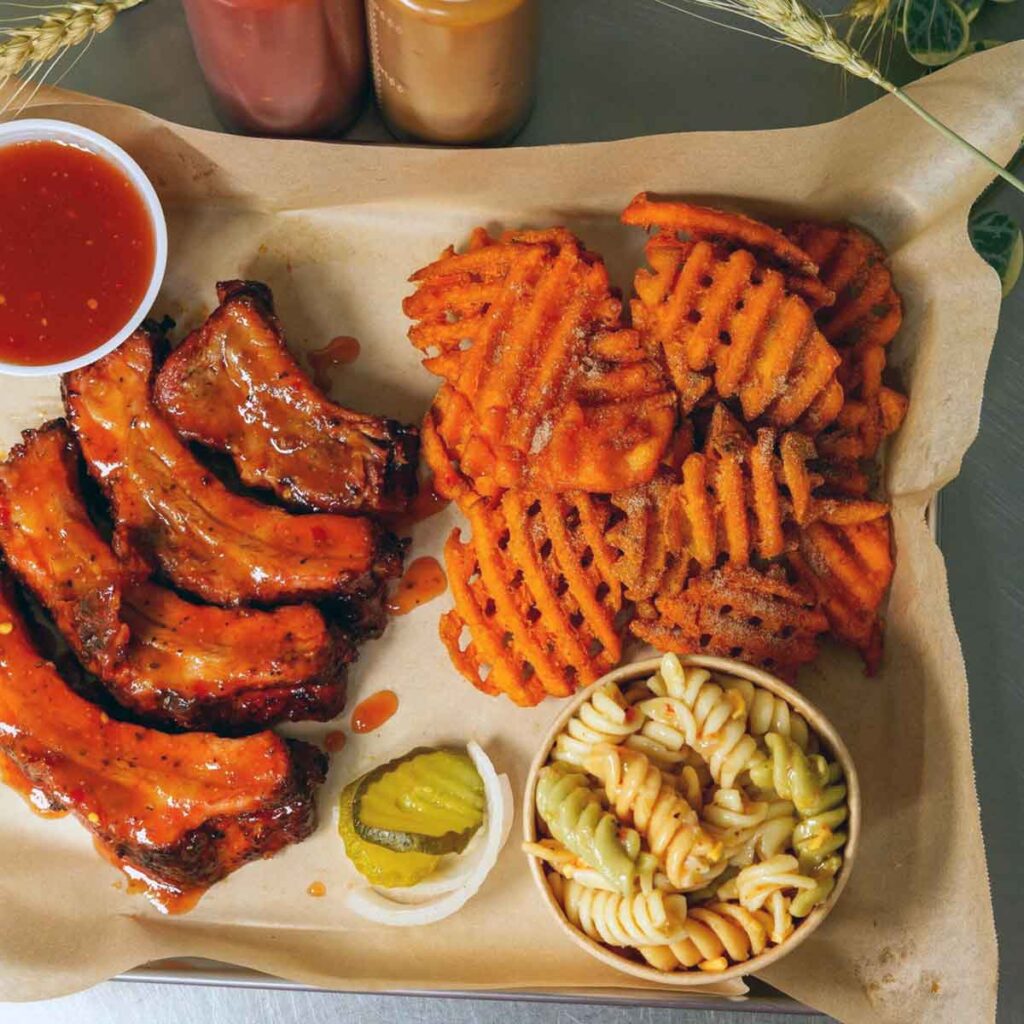 Sliced ribs with sweet potato fries and pasta salad.