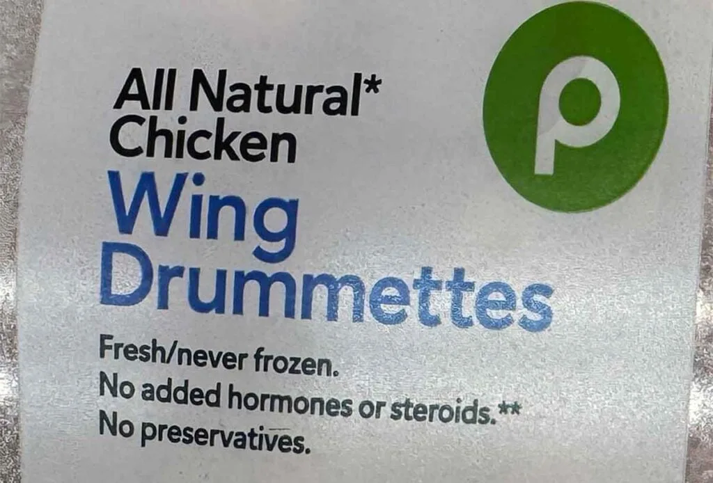 Chicken wing label showing &ldquo;fresh/never frozen&rdquo; and &ldquo;no preservatives,&rdquo; a common fresh-case claim set.