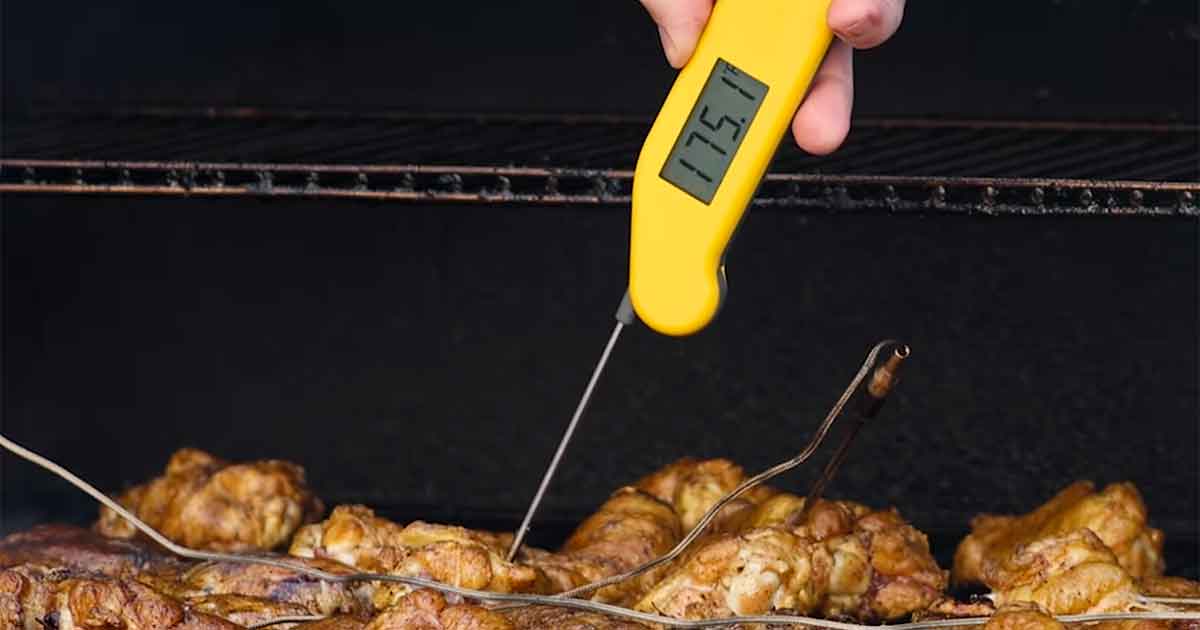 Chicken wing internal temperature at 175°F on an instant-read thermometer.
