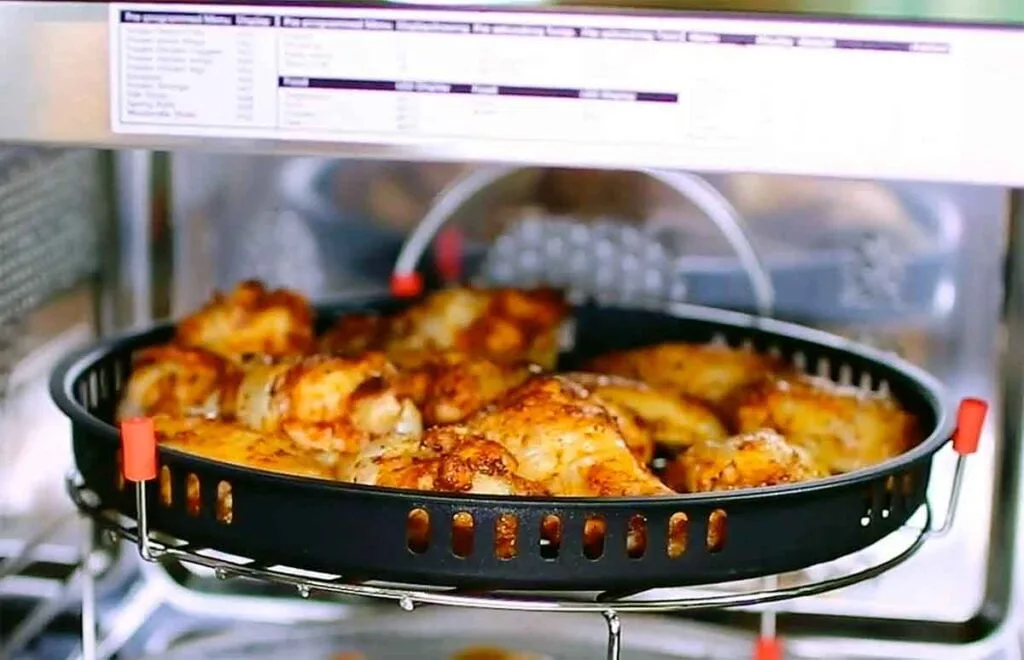 Wings warming in the microwave on a vented tray, before moving to dry heat to re-crisp the skin.